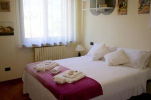 een slaapkamer met een bed met handdoeken erop bij Villa Carla Piemonte private pool in Melazzo