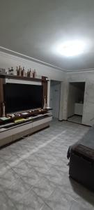 a large living room with a large television and a couch at Casa completa in Marília
