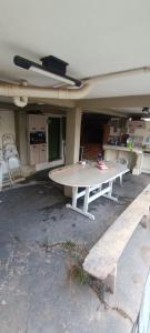 uma mesa de pingue-pongue e um banco numa garagem em Casa completa em Marília