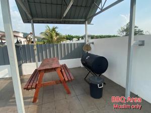 einen Grill und einen Picknicktisch auf einer Terrasse in der Unterkunft 892 Villa Dfaro Afamosa Melaka in Malakka