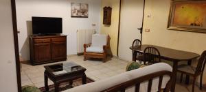 un soggiorno con TV, tavolo e sedie di Dimora Nonna Angela ad Alberobello