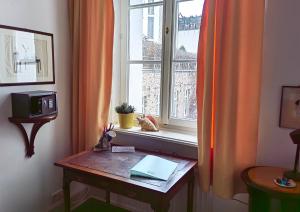 Epic Location في دوسلدورف: غرفة مع طاولة و نافذة مع الكمبيوتر المحمول