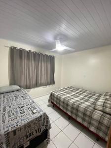 1 dormitorio con 2 camas y ventana en Apartamento Proximo Beto Carrero e Praia Armação, en Penha