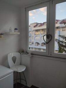 einen weißen Stuhl in einer Küche mit Fenster in der Unterkunft Apartman Lenka in Banja Koviljača