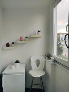 einen weißen Stuhl in einem Zimmer mit Fenster in der Unterkunft Apartman Lenka in Banja Koviljača