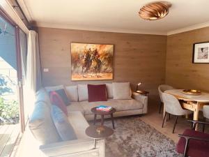 a living room with a couch and a table at Chalet Charm E4 Mowamba in Thredbo