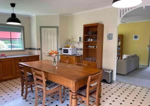 uma cozinha com uma mesa de jantar em madeira e cadeiras em Relaxing & beautiful Miner's cottage near Wilson’s Prom em Foster