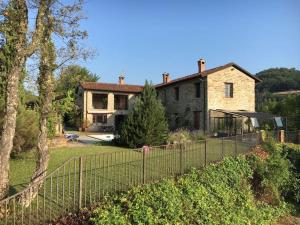 ein großes Haus mit einem Zaun davor in der Unterkunft Villa Natura Piemonte with pool in Castino