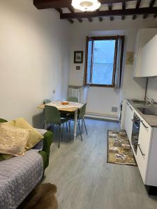 a living room with a couch and a table and a kitchen at Casa Borghellina in Montaione