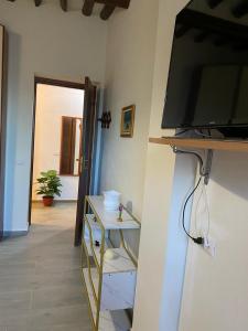 sala de estar con TV de pantalla plana en la pared en Casa Borghellina, en Montaione