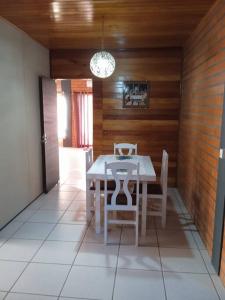 uma sala de jantar com uma mesa branca e cadeiras em Casa Tia Dori em Rio Forcação