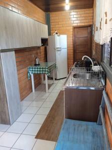 uma cozinha com um lavatório e um frigorífico em Casa Tia Dori em Rio Forcação