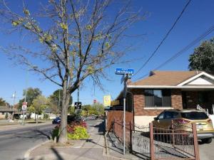 Comfortable entire 3BDR Apt in Laval Montreal في لافال: لافتة على الشارع امام منزل به شجرة