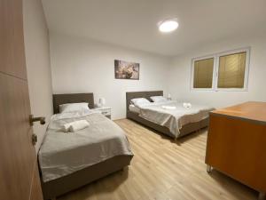 a room with two beds and a desk at FIA HOUSE Kozle in Ždanec