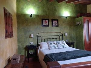 1 dormitorio con 1 cama y 2 mesas con lámparas en casa rural EL RICON, en Navadijos