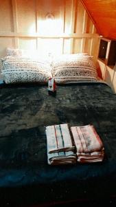 un letto con coperte e cuscini sopra di Chalé das Margaridas a Rio Forcação