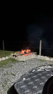 a fire pit in the ground at night at Chalé das Margaridas in Rio Forcação