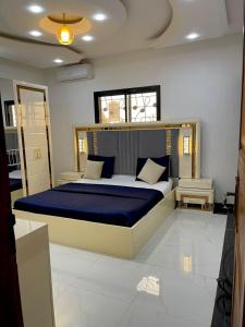a bedroom with a large bed with a blue blanket at SkyLight Residence in Yaoundé