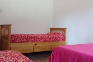 una camera con due letti con lenzuola rosse di Casa amplia en las sierras de San Luis a San Francisco del Monte de Oro