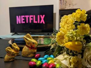 a table with easter eggs and a tv with the netflix sign at Winchester Retreat in Winchester