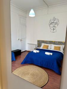 1 dormitorio con cama azul y espejo en Via Zara, en Palermo