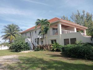 una casa con una palmera delante de ella en Coral Harbour Beach Apartment, en Nassau
