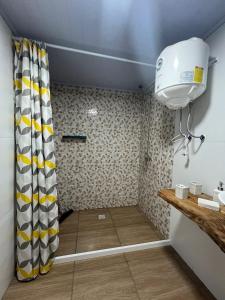 um chuveiro com uma cortina amarela e branca na casa de banho em Freyja em Chuy