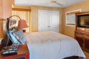 a bedroom with a bed and a flat screen tv at Orchid Suite in South Maui, across from the beach, 1 bedroom sleeps 4 in Kihei