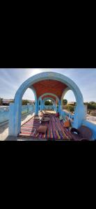a view of a patio with benches and an archway at Nuba life Mostafa Guesthouse in Najâ€˜ al MadÄbb