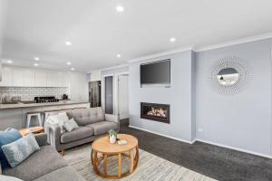 a living room with a couch and a fireplace at Hood Road Beach House- Hamptons inspired sleeps 9 in Indented Head