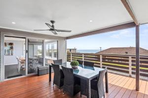 a dining room with a table and chairs on a balcony at Hood Road Beach House- Hamptons inspired sleeps 9 in Indented Head
