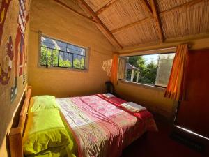 ein kleines Bett in einem kleinen Zimmer mit Fenster in der Unterkunft Posada Gloria in Tapay