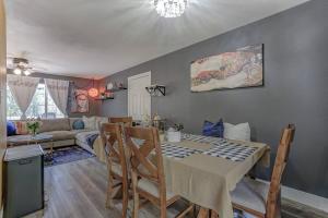 a kitchen and living room with a table and chairs at Cheerful 1-Bedroom Lake Cottage in Lakehead