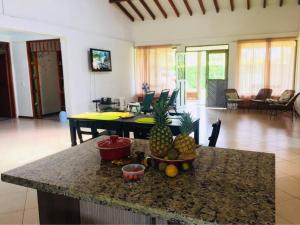 eine Küche mit einem Tisch mit Ananas auf der Theke in der Unterkunft Disfrute cabaña cálida, con piscina y zonas verdes in Viterbo