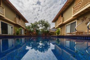 a swimming pool with chairs next to a building at Orchid Suite in South Maui, across from the beach, 1 bedroom sleeps 4 in Kihei