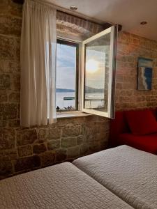 a bedroom with a window with a view of the ocean at Apartments Trapula in Šibenik