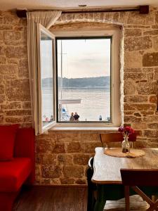 a living room with a table and a window at Apartments Trapula in Šibenik
