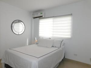 ein weißes Schlafzimmer mit einem Bett und einem Fenster in der Unterkunft Casa Florencia gran piscina in Salinas