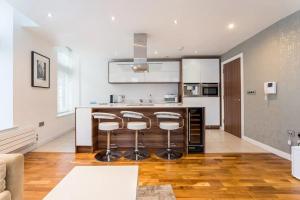 a kitchen with a bar with stools in it at Deansgate Luxury Apartments in Manchester