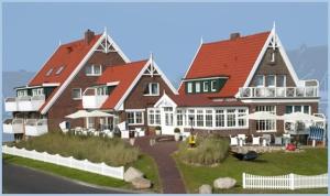 a large building with a red roof at Hotel Norderriff in Langeoog