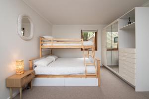 1 dormitorio con 2 literas y espejo en TJ's Tree House with Ocean Views, en Cape Schanck