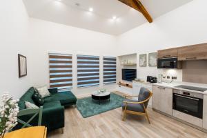 a living room with a green couch and a kitchen at Deansgate Luxury Apartments in Manchester