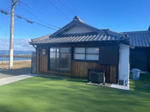 a small house with a green lawn in front of it at SEA&SEE KOSE in Kose