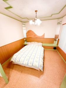a bedroom with a bed and a chandelier at ホテル亀岡 in Minamijō
