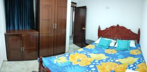 1 dormitorio con 1 cama con colcha azul y amarilla en Apartahotel San Isidro, en Monguí