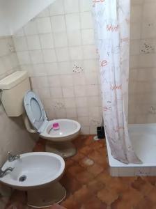 łazienka z toaletą, umywalką i wanną w obiekcie Rooms in a Girl House near Corroios Train Station w mieście Corroios