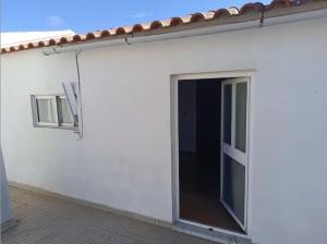 Biały dom z przesuwnymi drzwiami w obiekcie Rooms in a Girl House near Corroios Train Station w mieście Corroios