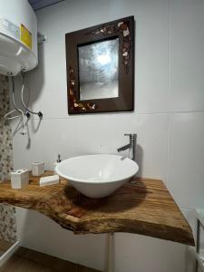 uma casa de banho com um lavatório branco num balcão de madeira em Monoambiente Freyja em Chuy
