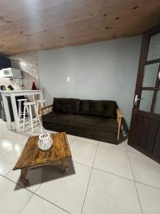 uma sala de estar com um sofá preto e uma mesa em Monoambiente Freyja em Chuy