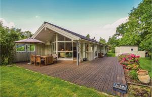 a house with a wooden deck in the yard at 3 Bedroom Gorgeous Home In Askeby in Askeby